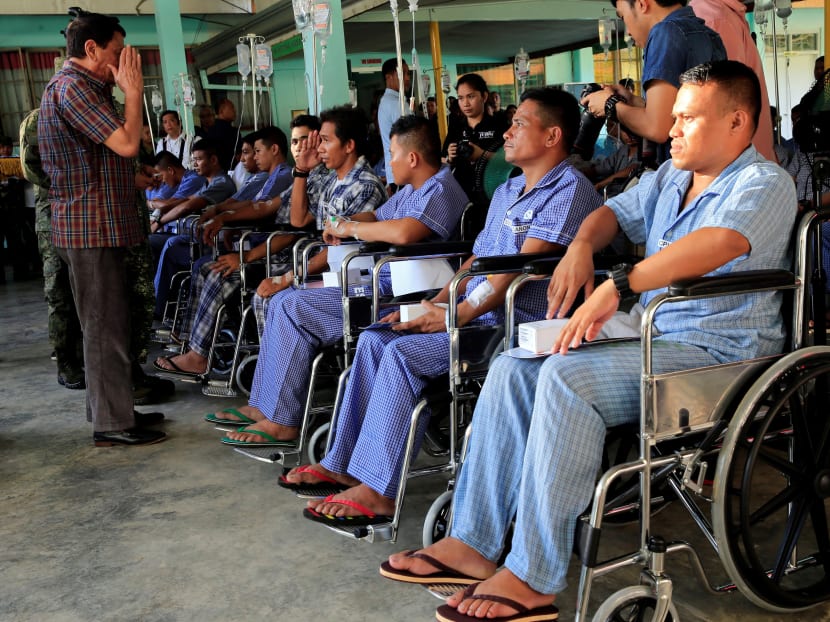 Philippines' President Rodrigo Duterte salutes a wounded soldier, who fights against the insurgents of the Maute group, which has taken over large parts of the Marawi city, during his visit at the military camp hospital in Cagayan De Oro, Philippines. Photo: Reuters