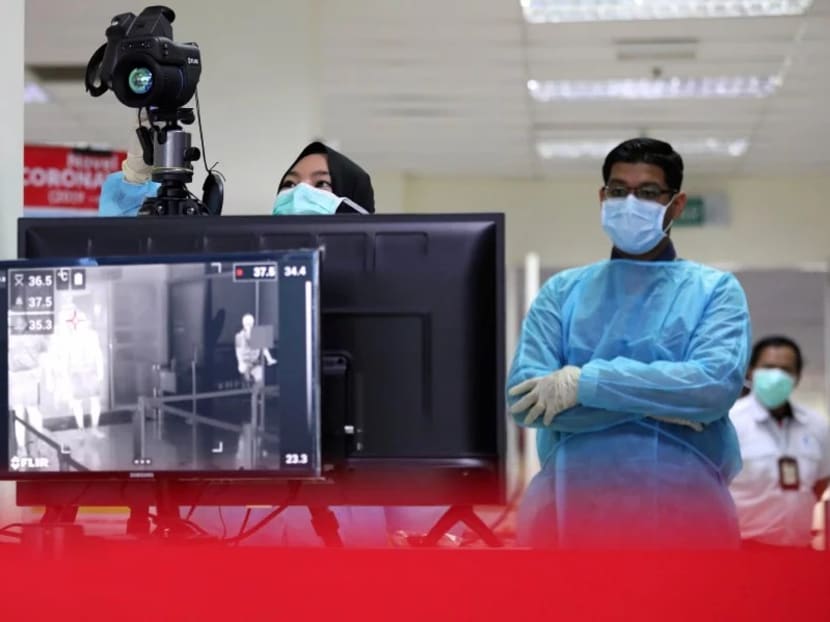 Malaysian health quarantine officers wait for passengers at a thermal screening point a cruise ship terminal, following the outbreak of the coronavirus in China, in Port Klang.