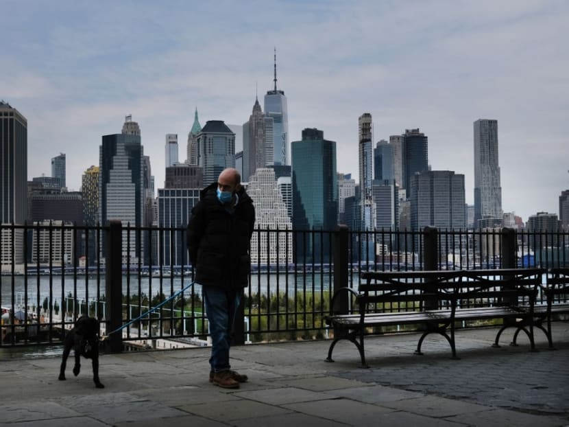 A man walks his dog along a promenade in Brooklyn on April 23, 2020 in New York City.