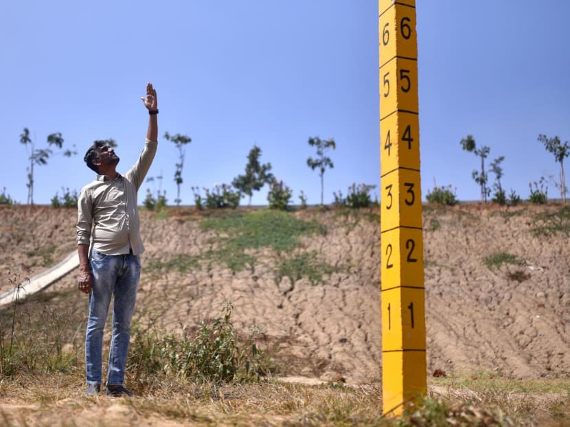 This photograph taken on Jan 29, 2024 shows mechanical engineer Anand Malligavad, known as "lake man" for his campaign to bring scores of lakes back to life, near a staff gauge used to measure water levels installed at the arid Doddathogur lake in Bengaluru. This photograph taken on Jan 29, 2024 shows mechanical engineer Anand Malligavad, known as "lake man" for his campaign to bring scores of lakes back to life, near a staff gauge used to measure water levels installed at the arid Doddathogur lake in Bengaluru.