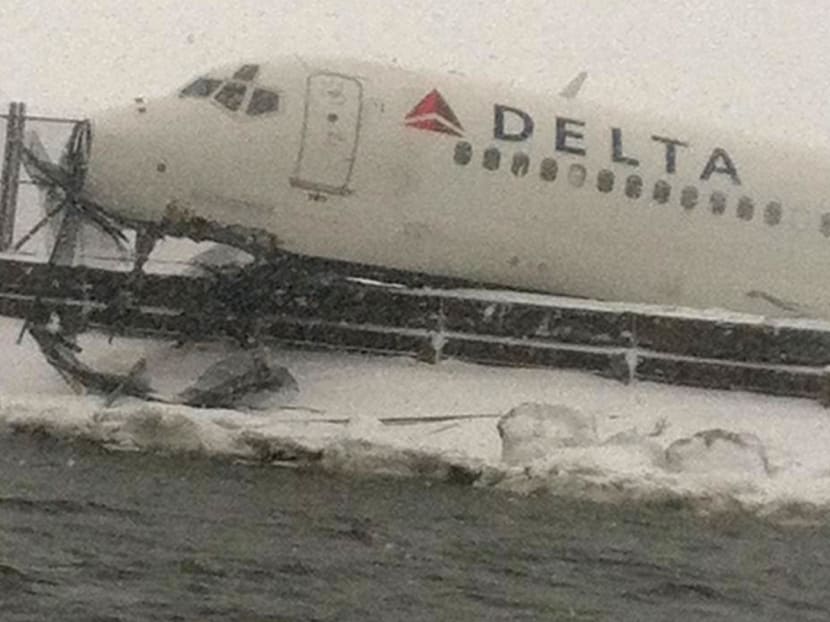 Plane skids off snowy New York runway, stops next to icy bay