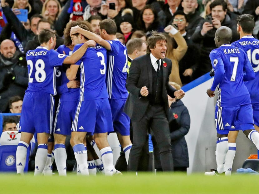 Chelsea players celebrate Eden Hazard’s goal with manager Antonio Conte during the EPL match against Everton at Stamford Bridge. Photo: AP