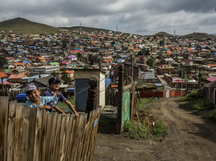 Boys climb a fence in one of Ulaanbaatar's suburbs in Mongolia, Aug 21. A scarcity of affordable housing has pushed thousands of low-income residents to the fringes of Ulaanbaatar, where they struggle for food and water. Photo: THE NEW YORK TIMES