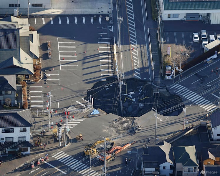 Japan sinkhole grows to almost Olympic pool length with truck driver still trapped