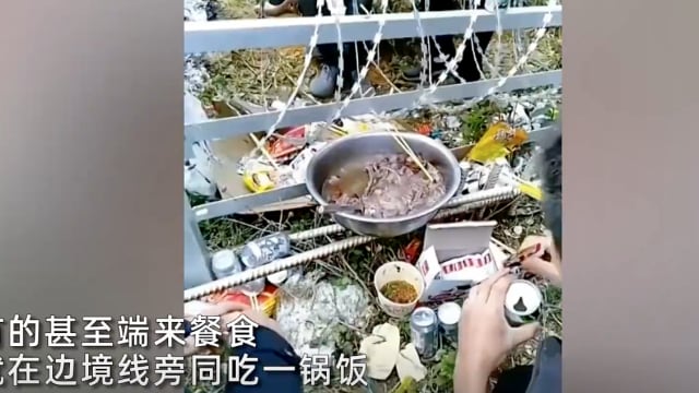 中越边境地区居民隔铁丝网庆新年 场面温馨