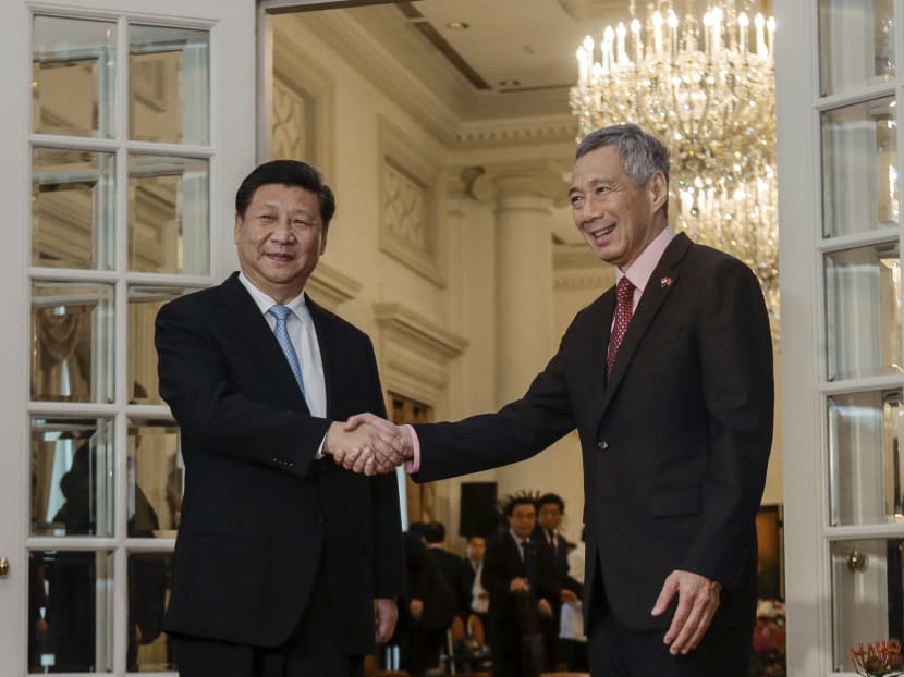 Chinese President Xi Jinping (L) and Singapore Prime Minister Lee Hsien Loong (R) shake hands for the media at the Istana presidential palace in Singapore, Nov 7, 2015. Photo: AP
