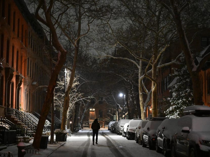 People walk through the snow in the Brooklyn Borough in New York on Jan 16, 2024.