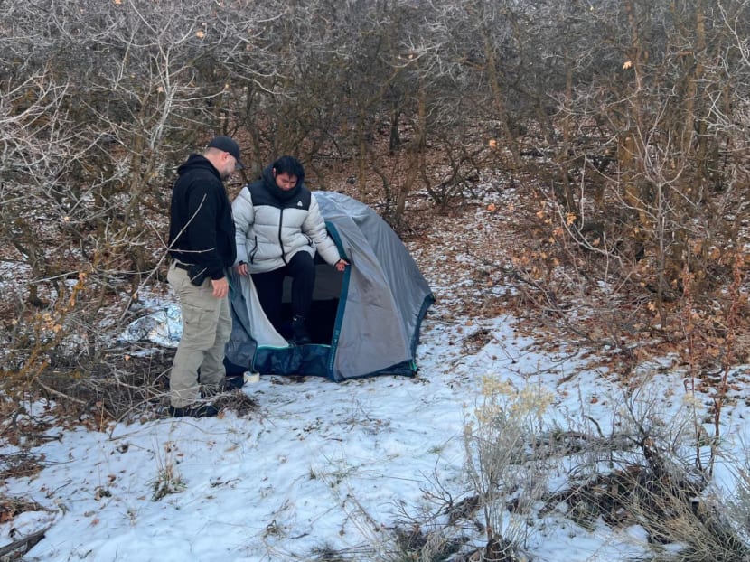 This handout photo released by the Riverdale Police Department on Jan 1, 2024 shows a police officer standing next with Kai Zhuang at the site where he was found in the mountains near Brigham City, Utah, on Dec 31, 2023, after being reported missing.