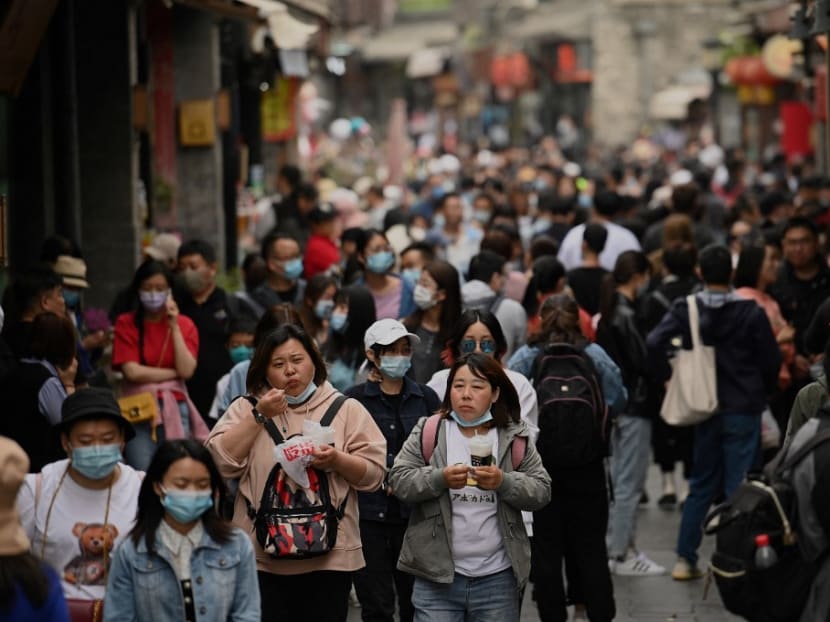 People walk through an alley near Houhai lake in Beijing during the Labour Day holidays, which take place from May 1 to May 5, on May 4, 2021.
