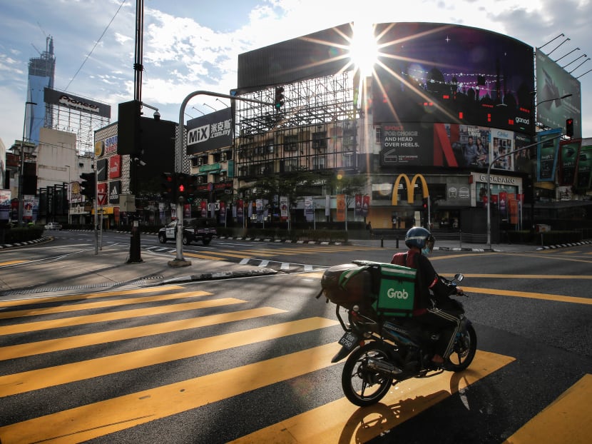 A food delivery man wearing a face mask rides on an empty street during the lockdown.