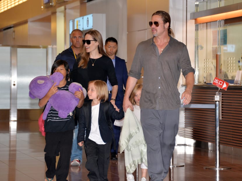 Brad Pitt and Angelina Jolie, accompanied by their children, arrive at Haneda International Airport in Tokyo on July 28, 2013.  Photo: AFP