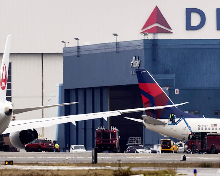 Japan Airlines plane wing clips parked Delta jet at Seattle airport