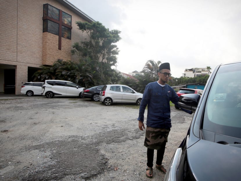 A mosque congregant walking to his car, parked at Spiritual Grace Presbyterian Church, after attending Hari Raya Aidilfitri activities at Masjid Ahmad Ibrahim yesterday. Photo: Jason Quah