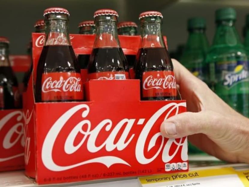 An employee arranges bottles of Coca-Cola at a store in Alexandria. Photo: Reuters