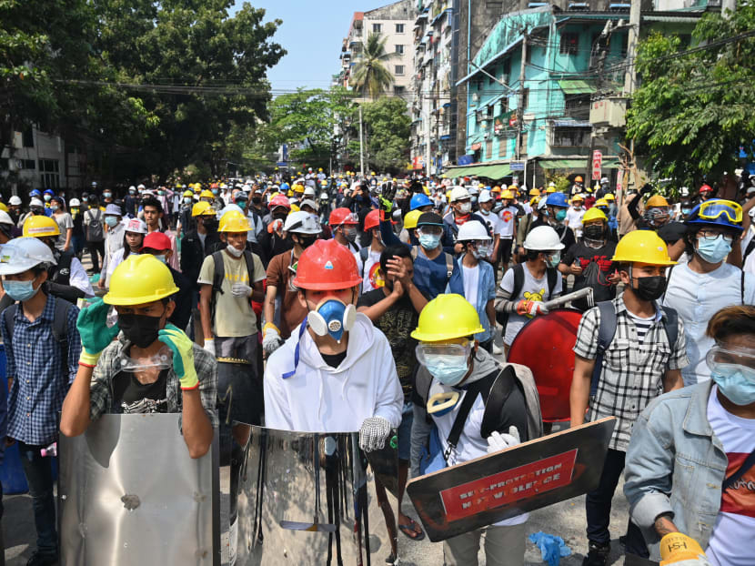 Protesters wearing protective gear gather on a road during a demonstration against the military coup in Yangon on March 3, 2021.
