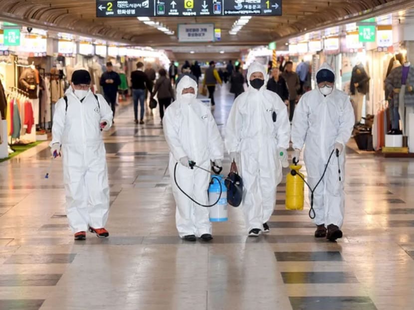 Employees from a disinfection service company sanitize the floor of a shopping center in Daejeon, South Korea, Feb 22, 2020.
