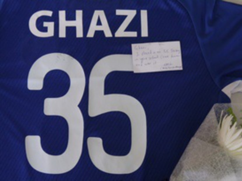 A football jersey was placed at TKPS for missing teacher Mohammad Ghazi Mohamed by Mr Abdul Nasir, manager of the MOE football team. Photo: Don Wong