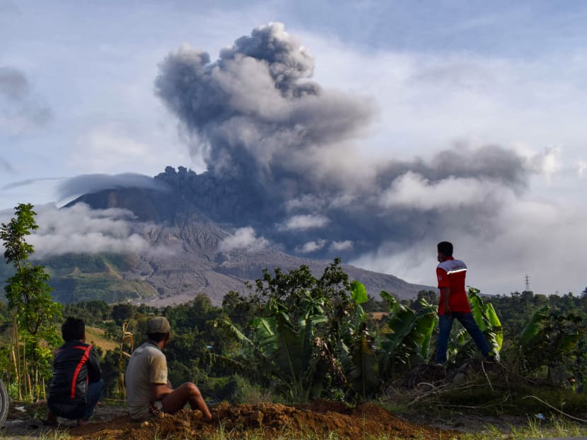 Villagers watch the eruption of Mount Sinabung as seen from Karo, North Sumatra on Aug 13, 2020.