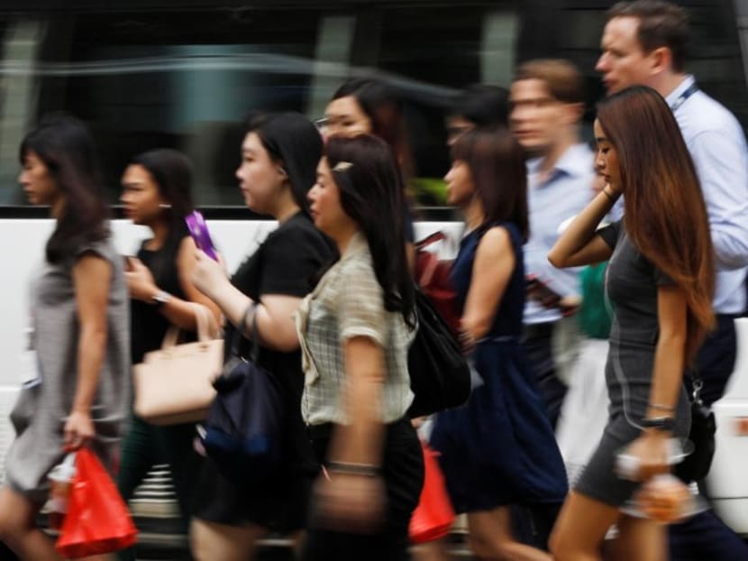 Office workers cross a street in Singapore's central business district.