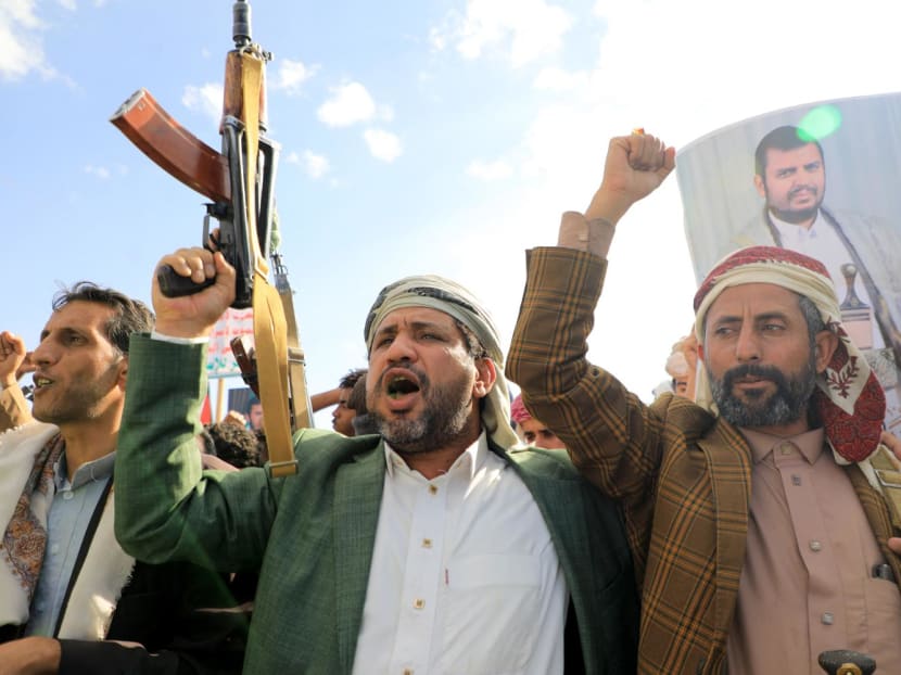 Yemeni men brandish their weapons and hold up portraits of Houthi leader Abdul Malik al-Houthi during a protest in solidarity with the Palestinian people in the Houthi-controlled Yemeni capital Sanaa on Jan 5, 2024, amid the ongoing battles between Israel and the militant Hamas group in Gaza. 