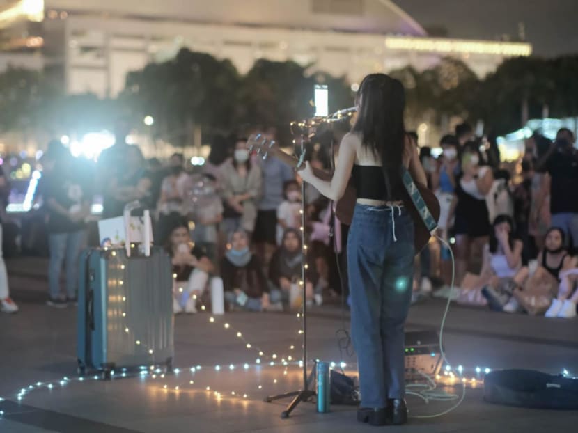 Busker Delvina See performing to a street crowd in Singapore. Busker Delvina See performing to a street crowd in Singapore.