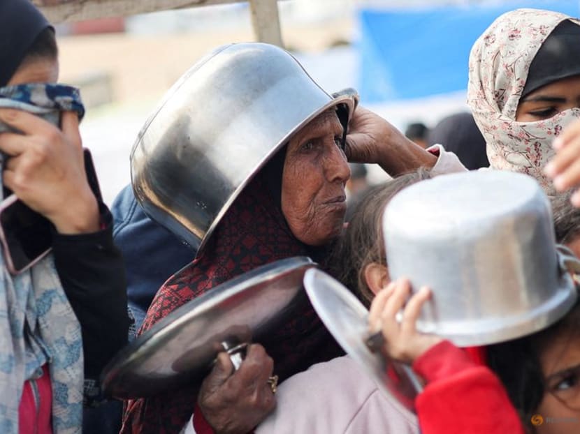 Displaced Palestinians wait to receive free food at a tent camp, amid food shortages, as the conflict between Israel and Hamas continues, in Rafah in the southern Gaza Strip, on Feb 27, 2024.