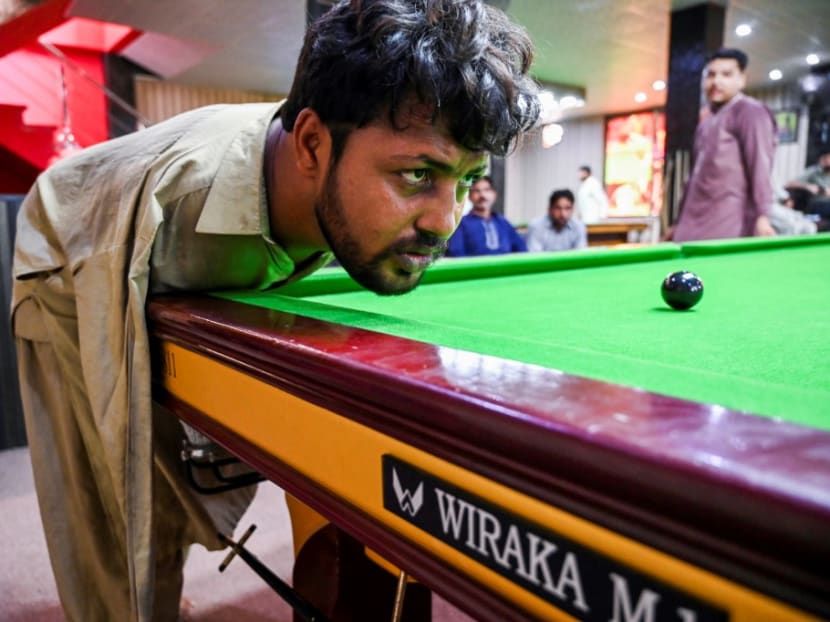 Mr Muhammad Ikram lines up a shot at a local snooker club in Samundri.