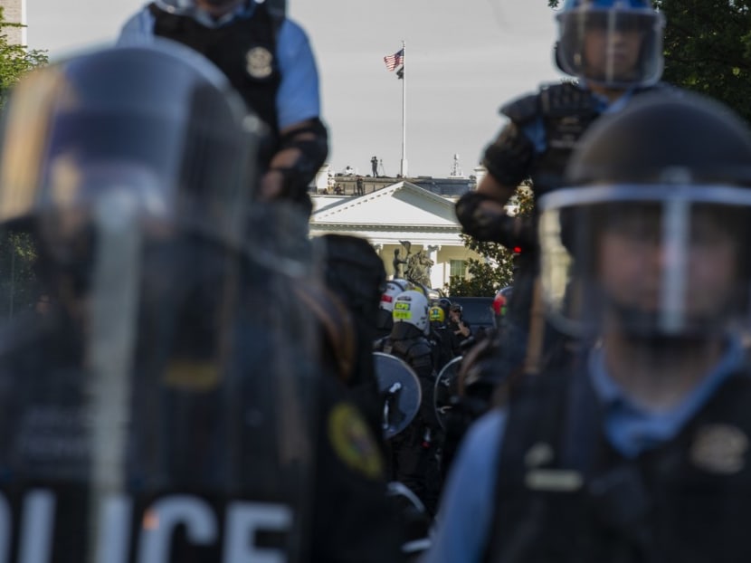 The White House is seen behind a line of park police officers wearing riot gear as they push back demonstrators outside of the White House, June 1, 2020 in Washington DC, during a protest over the death of George Floyd.