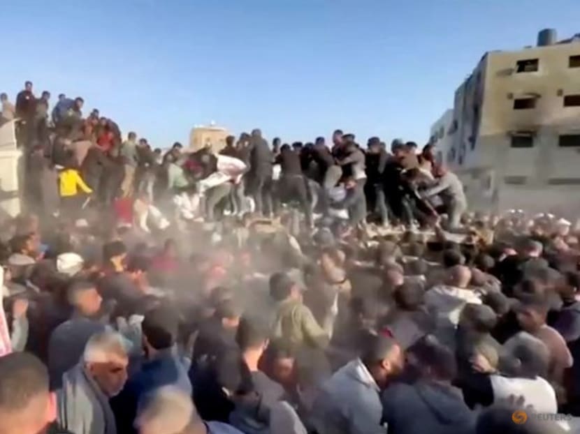 People rush towards an aid truck carrying bags of flour in Al Zaytun neighbourhood, amid the ongoing conflict between Israel and the Palestinian Islamist group Hamas, in Gaza City, in this still picture taken from a video, on March 2, 2024. 