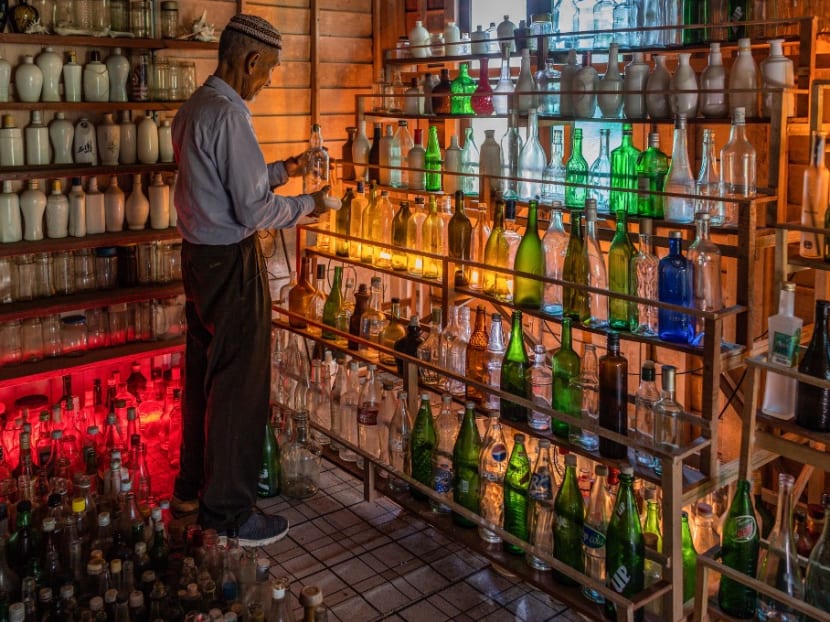 Mr Mohamad Ali Mansor inspects a glass bottle at his bottle museum in Penarik village in the Setiu district of the eastern Malaysian state of Terengganu. Mr Mohamad Ali Mansor inspects a glass bottle at his bottle museum in Penarik village in the Setiu district of the eastern Malaysian state of Terengganu.