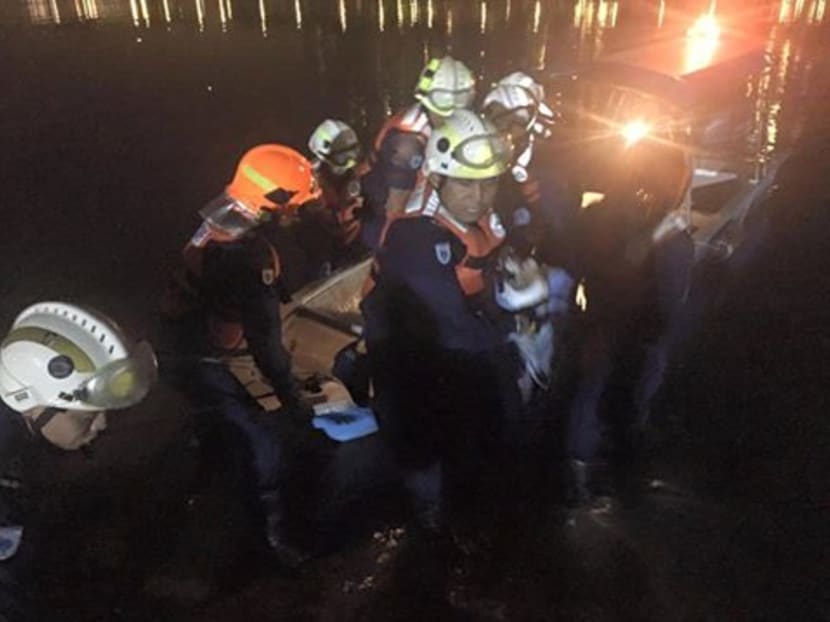 Firefighters retrieve the body of a missing boatman on July 13. Photo: Singapore Civil Defence Force