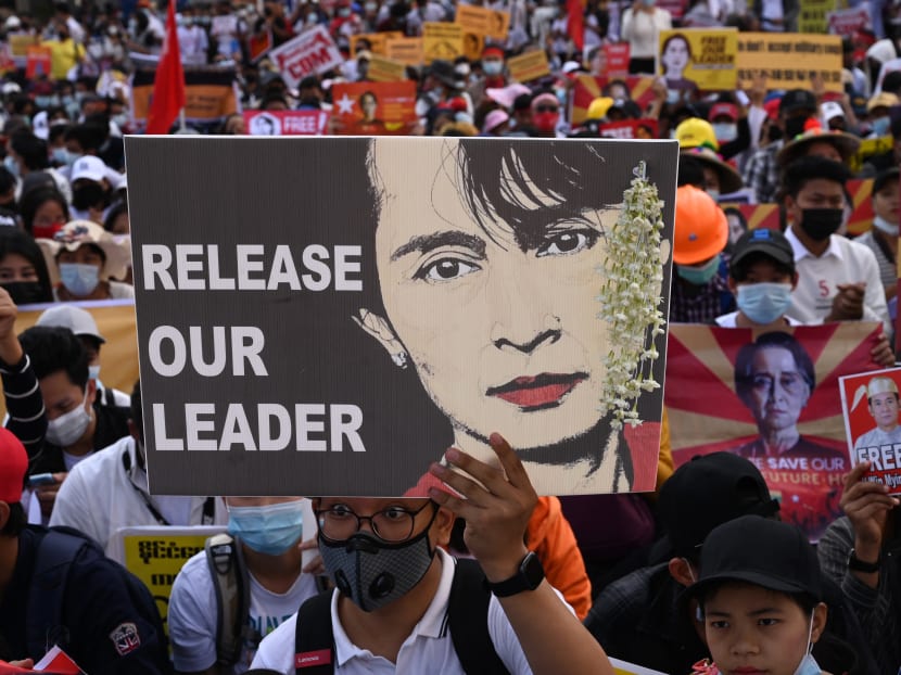 A protester holds a sign calling for the release of detained Myanmar civilian leader Aung San Suu Kyi as they block a road during a demonstration against the military coup in Yangon on February 17, 2021.