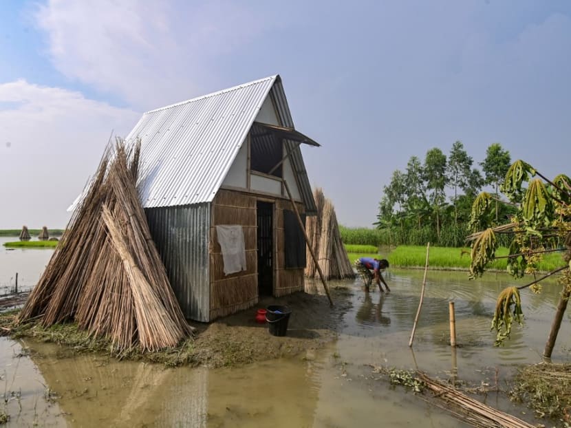 In this photograph taken on September 3, 2023, a man works near the "Khudi Bari" or "tiny house", a mobile modular shelter, in Char Shildaha. 