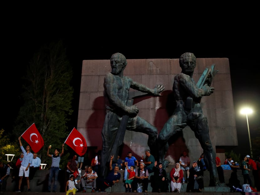 People sit in front of a statue as they gather in solidarity night after night since the July 15 coup attempt in central Ankara, Turkey. Photo: REUTERS