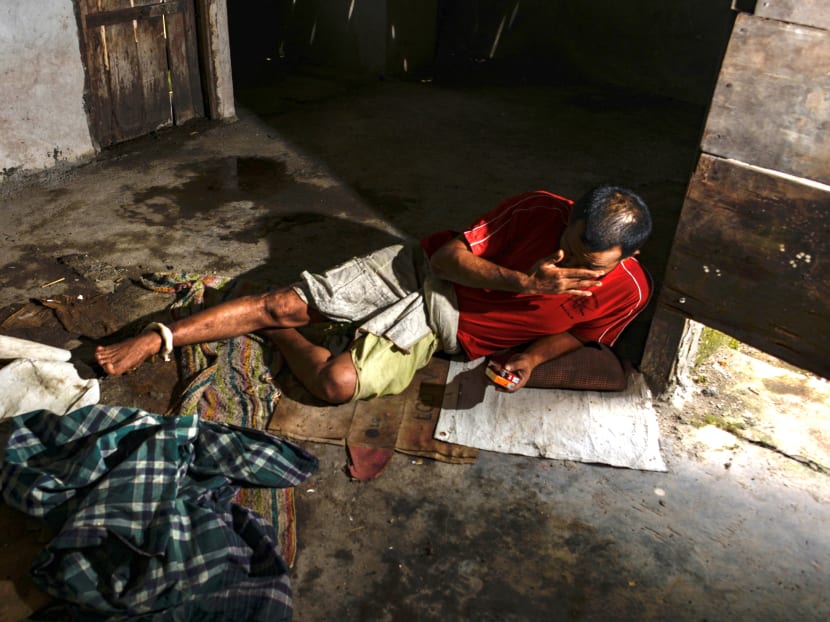 This photo taken on July 9, 2020 shows a man with a mental health condition with his leg shackled sitting on the floor in a locked room at his home in Labuhan Haji in Southern Aceh province.