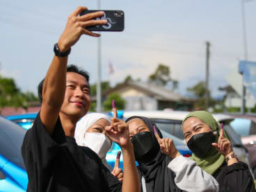 Young voters taking a wefie with their ink-stained index fingers after voting at a polling centre in Satok, Kuching on Nov 19, 2022. 