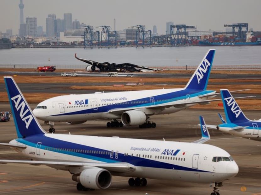 Officials investigate a burnt Japan Airlines' (JAL) Airbus A350 plane after a collision with a Japan Coast Guard aircraft at Haneda International Airport in Tokyo, Japan January 3, 2024.  REUTERS/Issei Kato