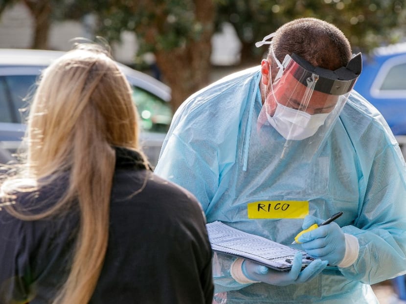 A health worker takes details at a Covid-19 testing station setup at Eden Park, National Sports Stadium, in Auckland on Aug 14, 2020.