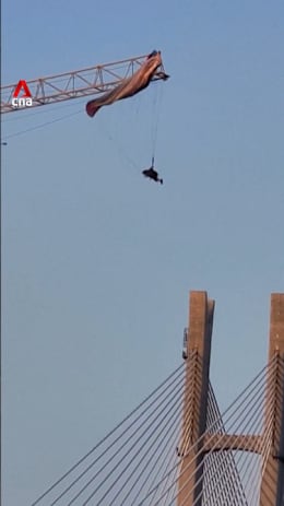 Paraglider in China gets caught on crane