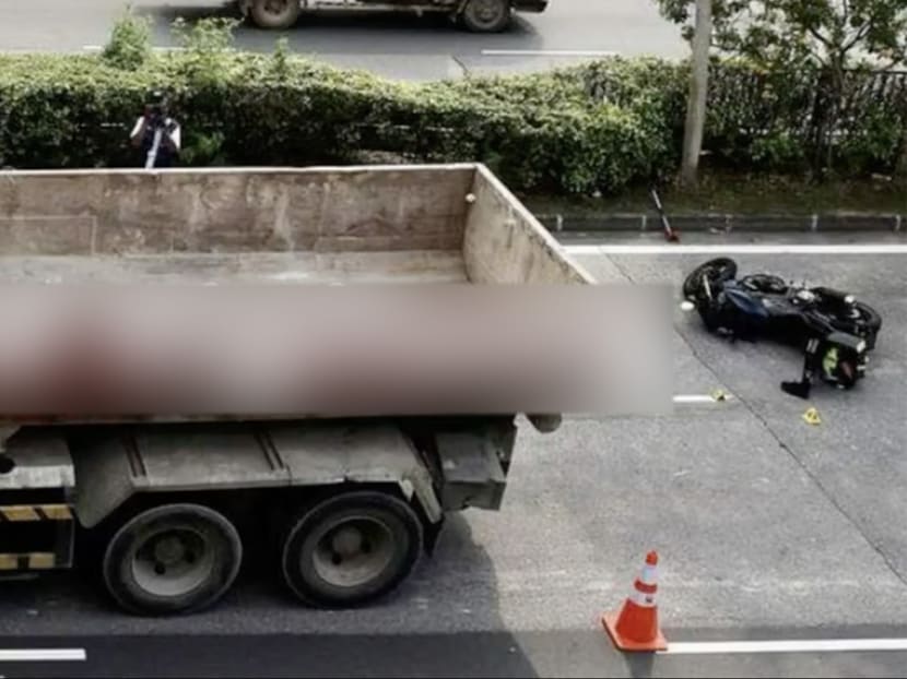A photo of the accident showing a tipper truck and a motorcycle lying on its side.