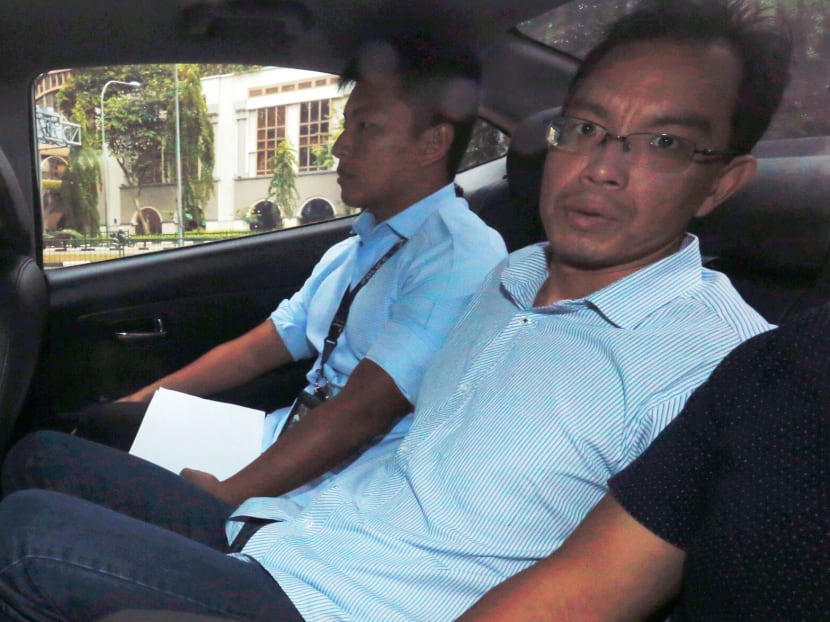 Yan Jun (right) entering the State Courts in a police car in July 2017. Yan Jun (right) entering the State Courts in a police car in July 2017.