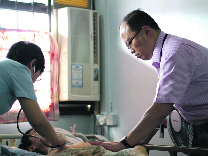 Dr Chan Yeow on a home visit with Nurse Clinician Sun Tao to change the tracheotomy tube and make an assessment of ventilatory adequacy for a patient on the Home Ventilation Service. He and his team visit patients using  this service  about once a month. Photo: Tan Tock Seng Hospital