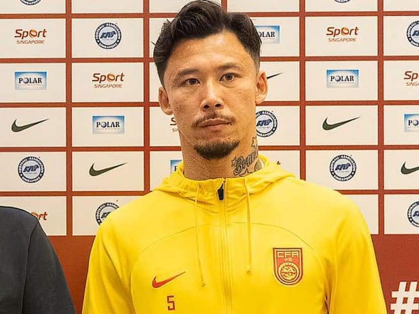 China's football captain Zhang Linpeng posing for photographers at a press conference on March 20, 2024 ahead of a Fifa World Cup qualifier against Singapore.