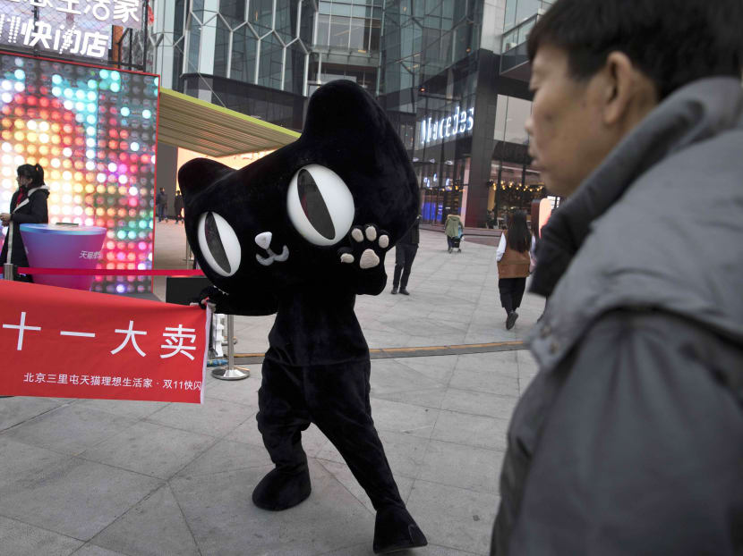 A mascot for Tmall, an online shopping website owned by Alibaba, holds up a banner with the word "Double 11 big sale" during an event to promote Singles Day in Beijing on Monday, Nov 6, 2017. Photo: AP