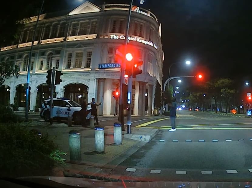 A screengrab from a YouTube video showing police officers pointing their weapons at a man along Stamford Road.