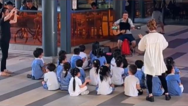 幼儿观赏街头表演边唱边拍手 网民：超暖心！