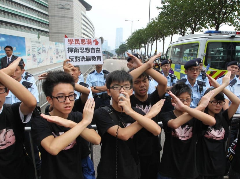 Members of student group Scholarism, including its convenor Joshua Wong Chi-fung, protest at Golden Bauhinia Square.