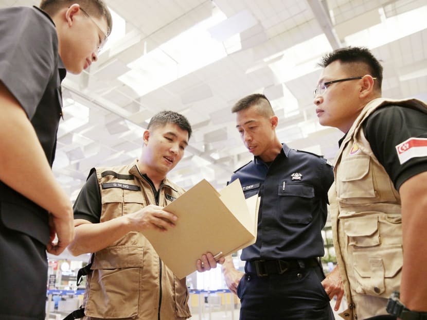 Singapore Civil Defence Force officers, Lieutenant-Colonel Ng Geok Meng (second from left) and Major Stuart Koh (right), with their colleagues at Changi Airport before leaving for Aceh, Indonesia, yesterday. The duo are part of a regional emergency response and assessment team which will help determine critical resources needed, and are expected to be there for a week. PHOTO: Jason Quah