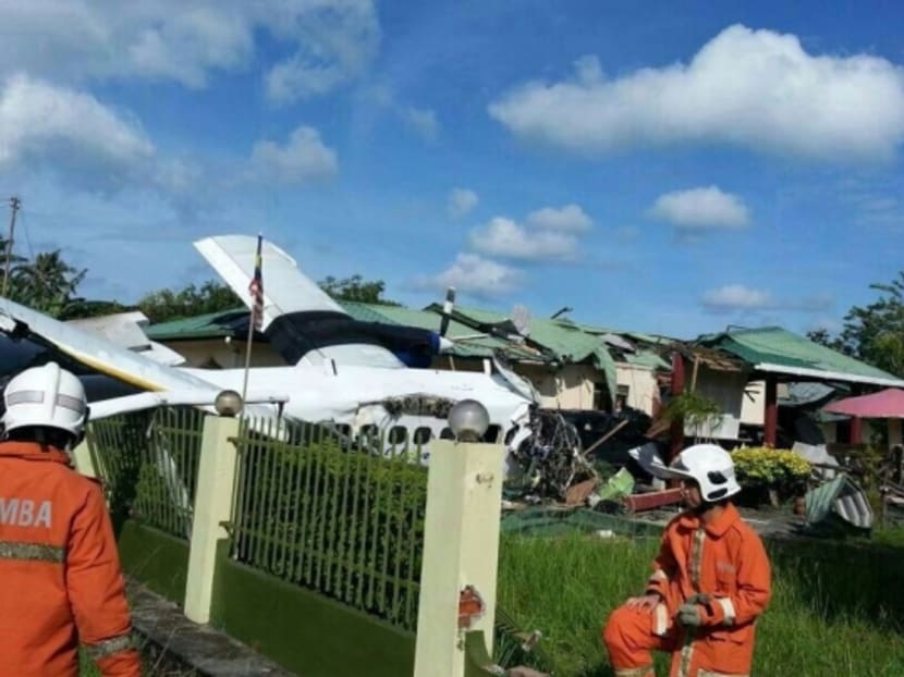 Rescue personnel going through the crash site at a vacant house in Sabah today. Photo: The Malaysian Insider