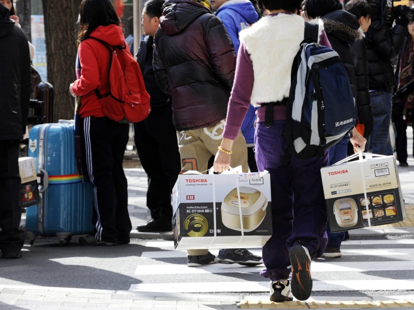 A Chinese tourist carrying rice cookers in Akihabara, Tokyo. China’s infatuation with Japanese products is discovering a new source of satisfaction: The Internet. PHOTO: AFP